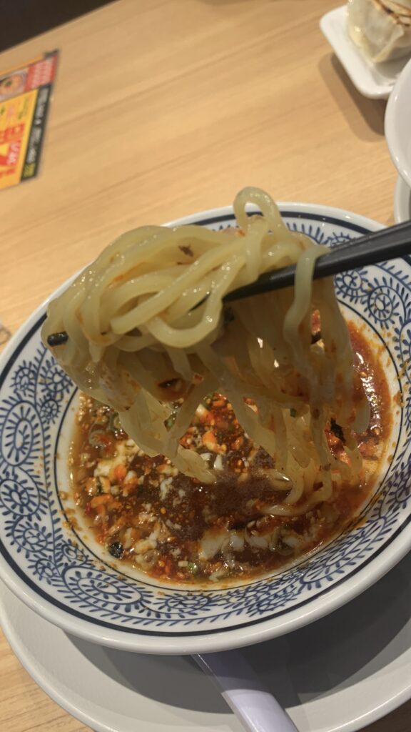 丸源ラーメン 旨辛肉つけ麺 旨辛肉つけ麺 麺をつけ汁にくぐらせたところ