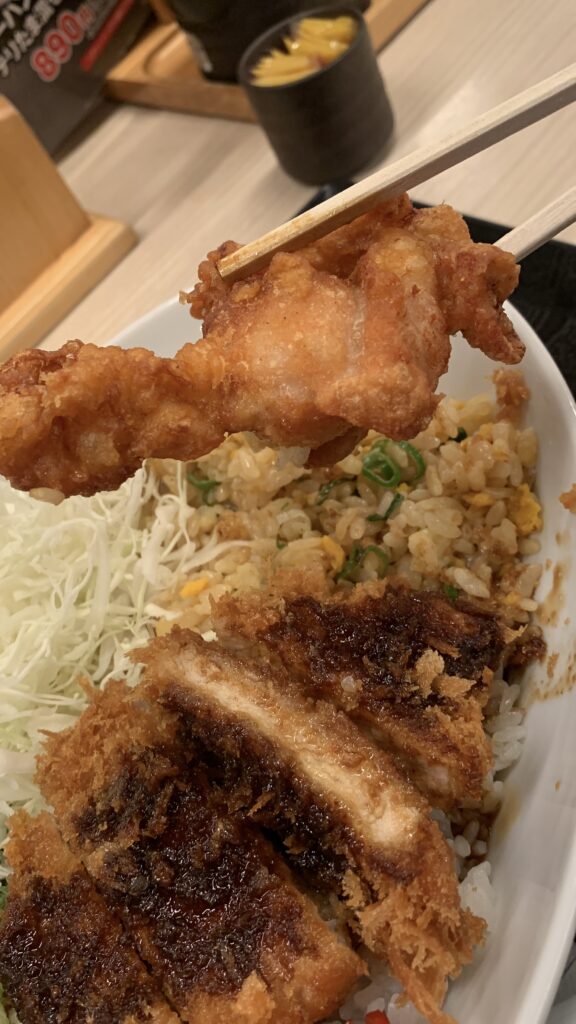 かつや 欲張り飯のから揚げを箸で持ち上げたところ