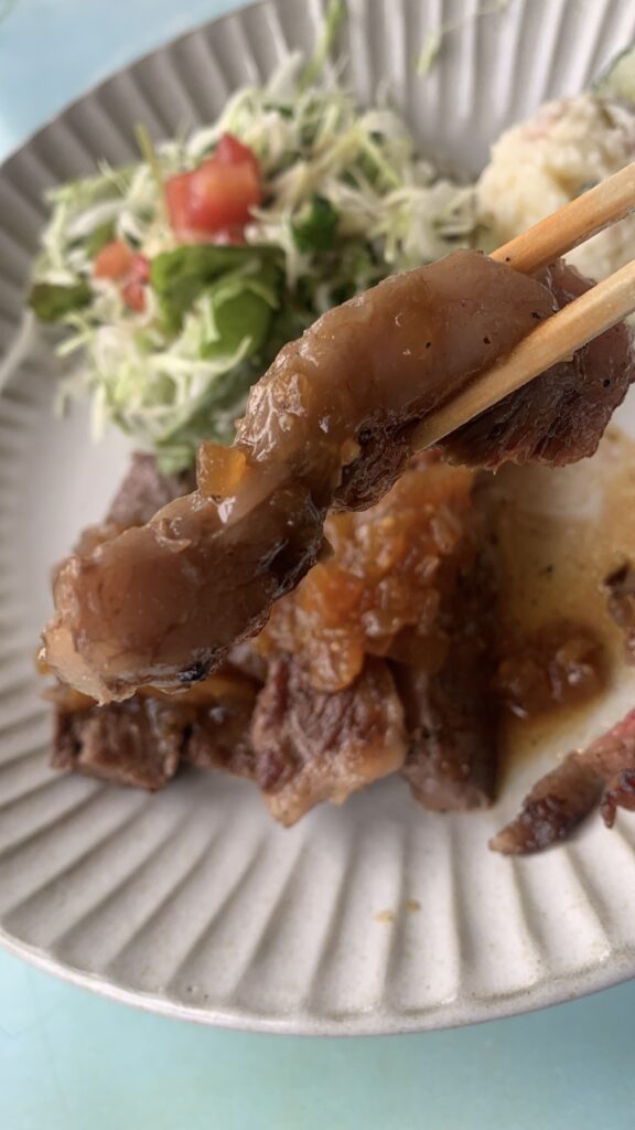 Casual Kitchen Hana ステーキランチ ステーキを箸でもち上げたところ ソースがかかった肉厚の断面