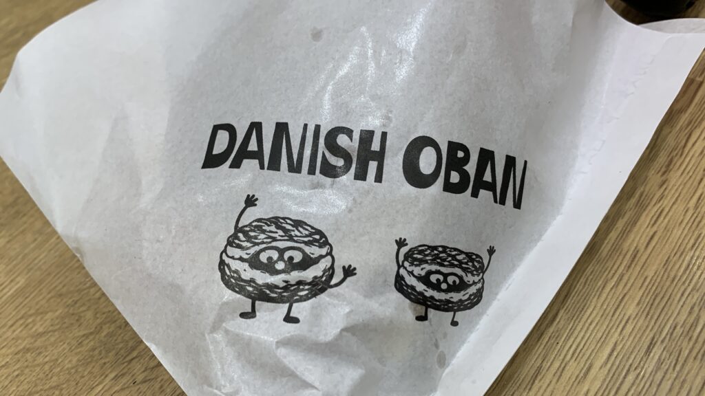「DANISH OBAN」のロゴとキャラクターが描かれた紙袋のアップ