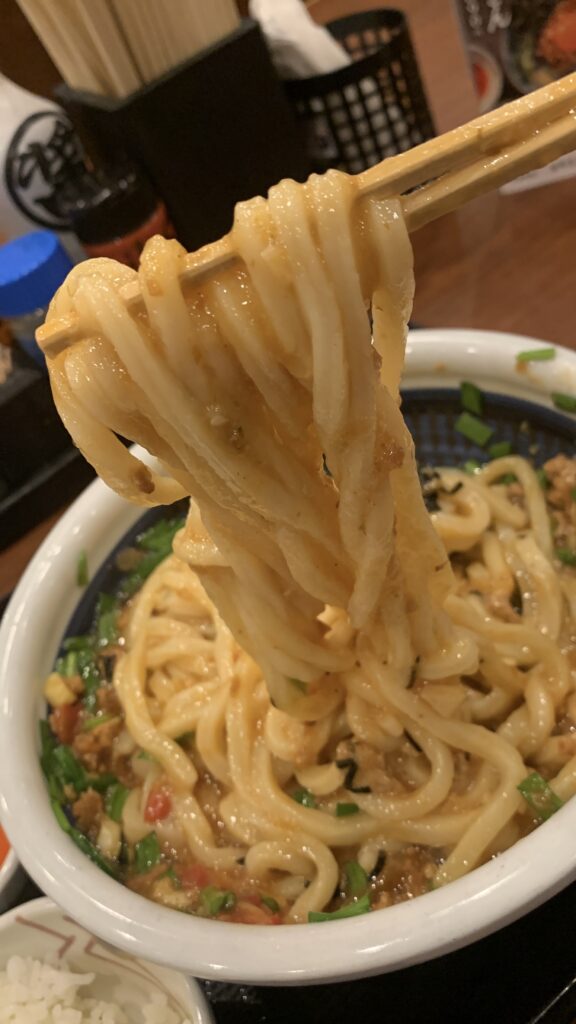 丸亀製麺 肉辛まぜうどん うどんにミンチが絡んだところ 箸でもち上げ